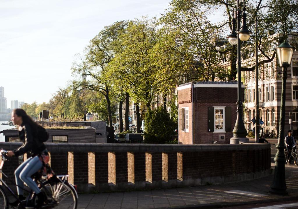 a woman riding a bike on a bridge at SWEETS - Nieuwe Amstelbrug in Amsterdam