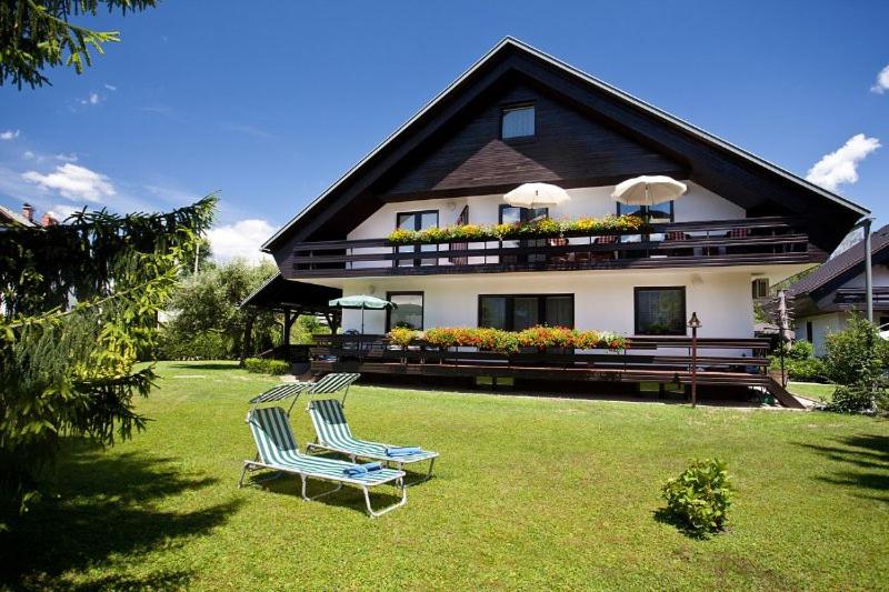 twee stoelen op een gazon voor een huis bij Lake Bled Apartment Marjetka in Bled