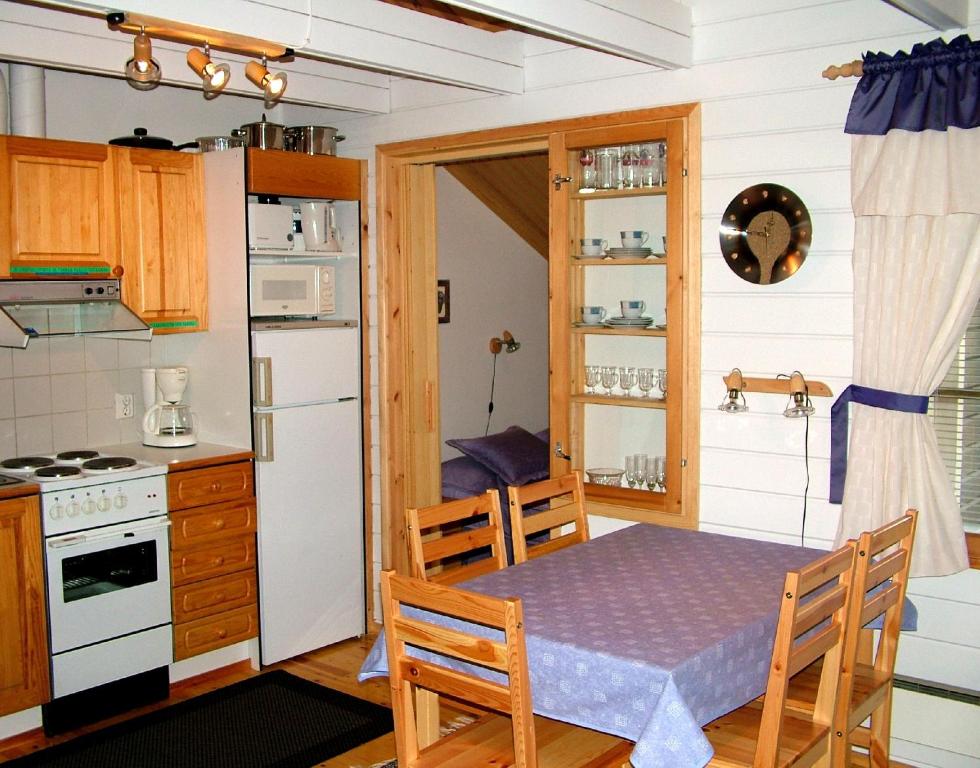 a small kitchen with a table and a refrigerator at Ylläsriemu Apartments in Äkäslompolo