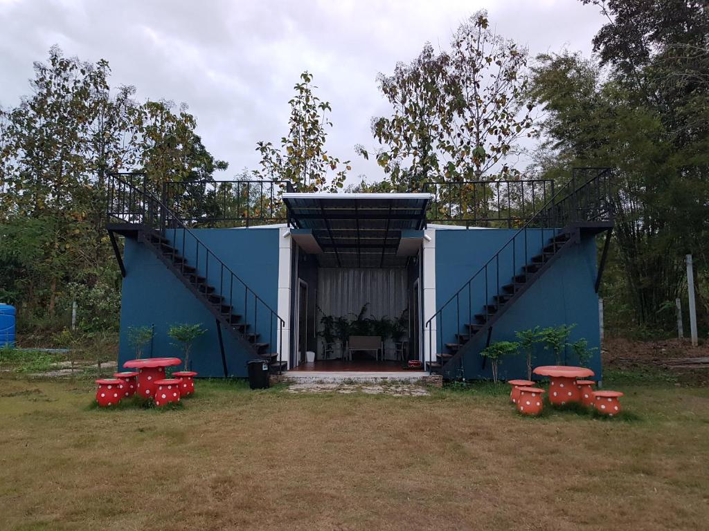 un edificio azul con mesas rojas y una escalera en The Letter en Chiang Khan