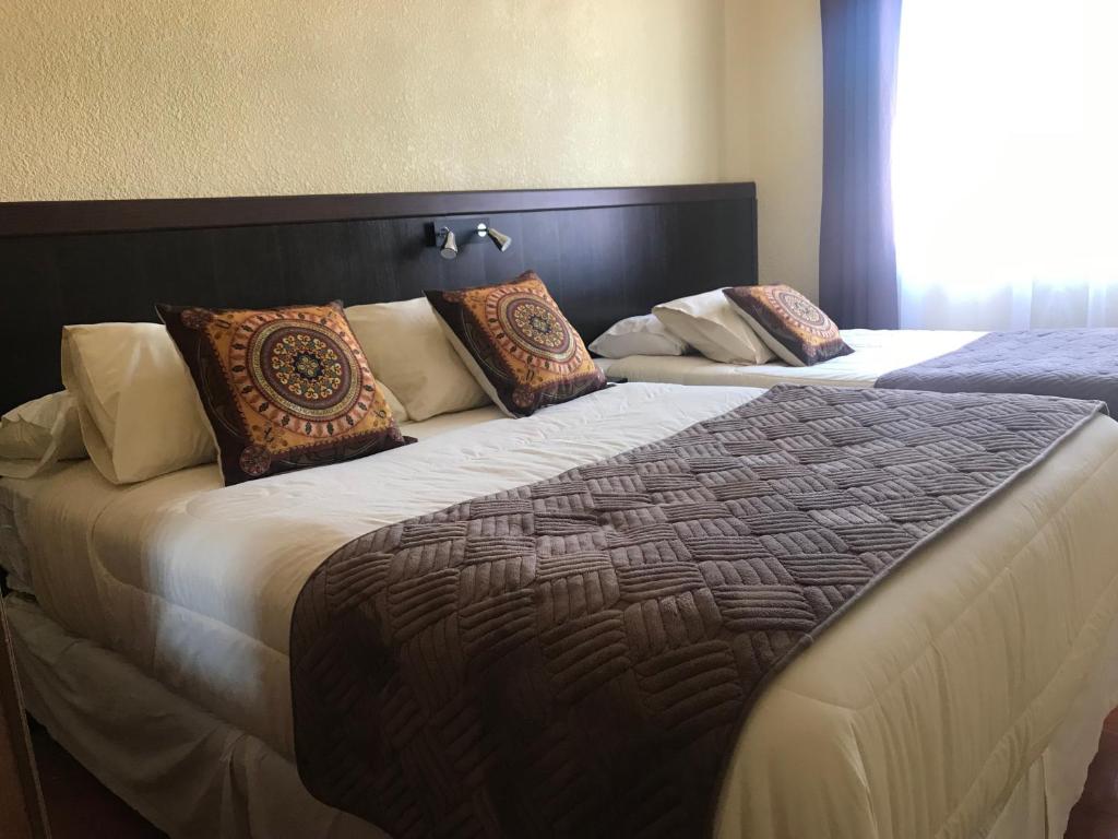 a bedroom with two beds with pillows at Inti Hotel in Combarbalá