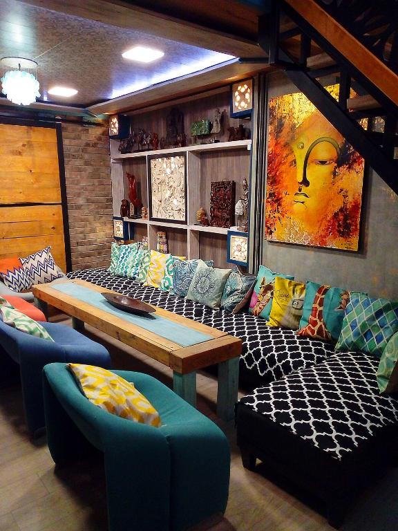 Una habitación con un sofá, una mesa y sillas. en NapPARK Hostel, en Belgrado