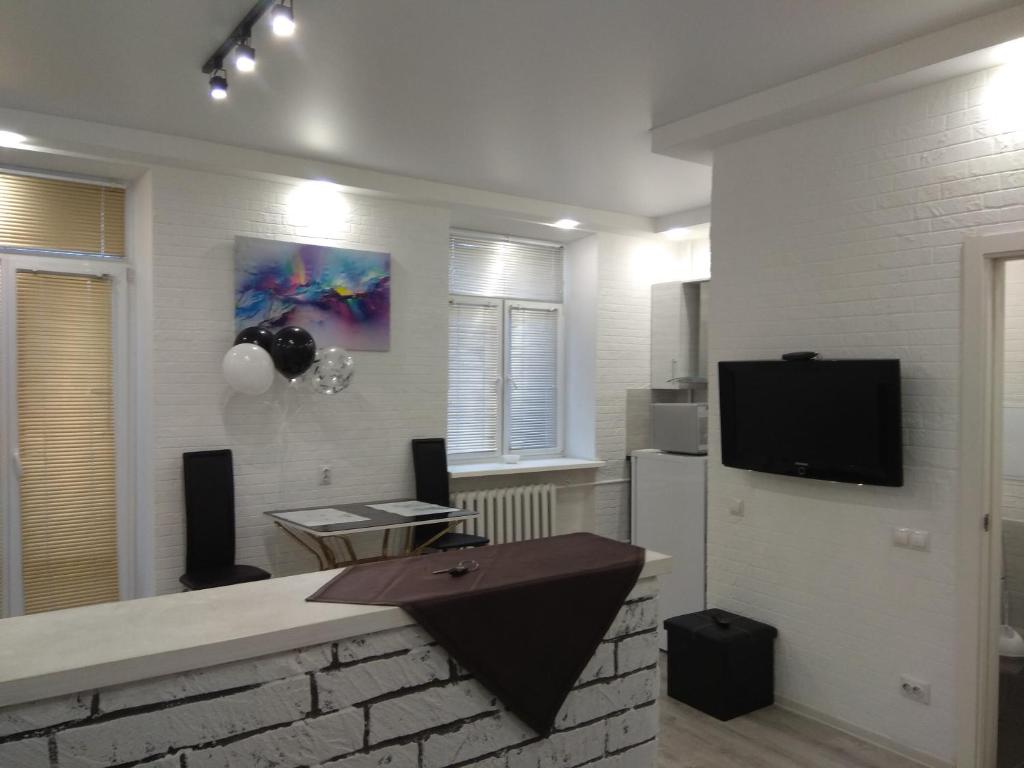 a living room with a tv on a brick wall at Шикарные Апартаменты in Polatsk