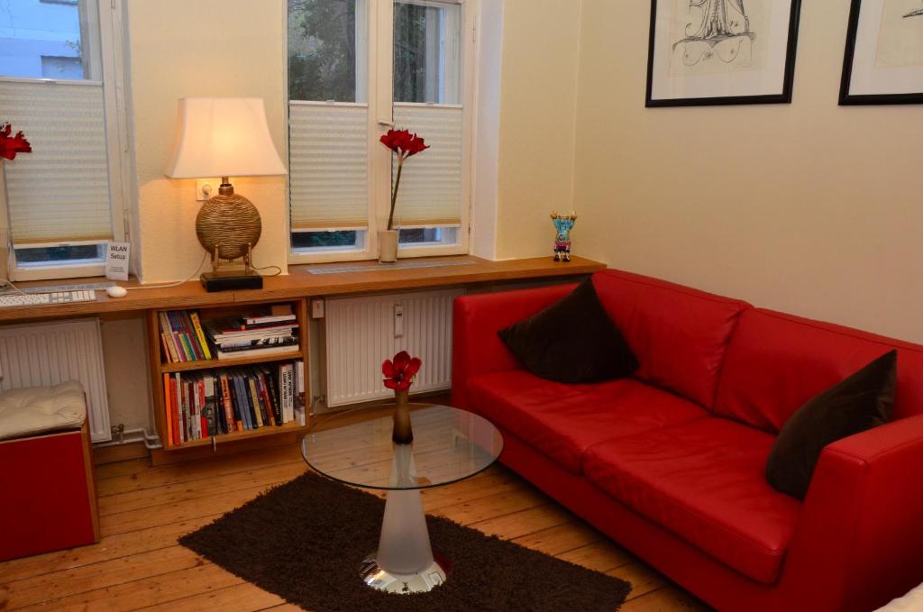 uma sala de estar com um sofá vermelho e uma mesa em Zentral gelegen - stilvolles Appartment in Moabit em Berlim