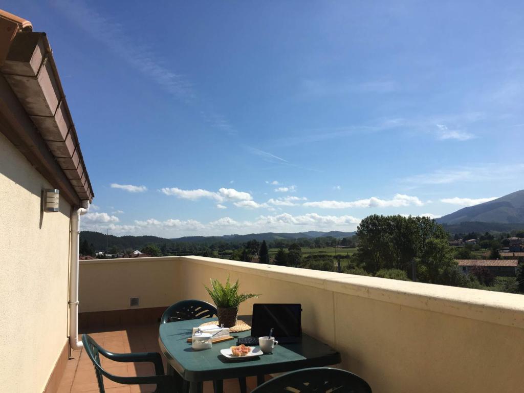 eine Terrasse mit einem Tisch und Stühlen auf dem Balkon in der Unterkunft Ático Nuevo con vistas in Cabezón de la Sal