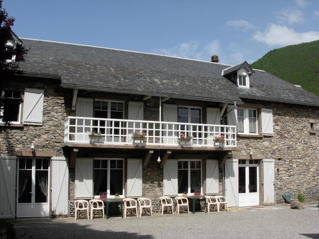 a building with tables and chairs in front of it at Maison Fouga in Cadéac