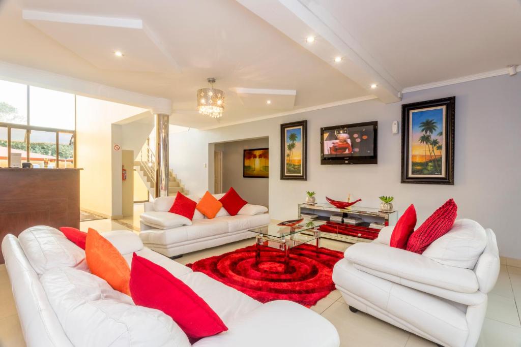 a living room with two white couches and a red rug at Ezulwini Guest House in Ballito