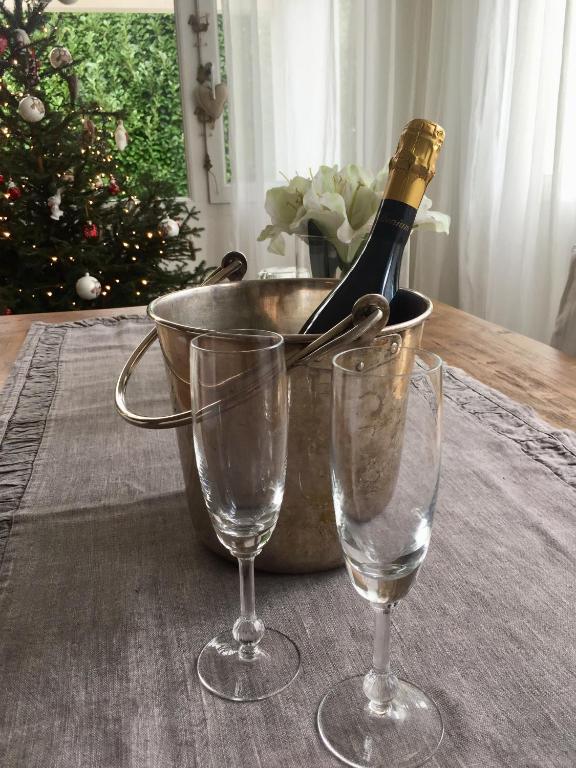 butelkę szampana w wiadrze obok dwóch kieliszków w obiekcie Villa Alice w mieście Lesa