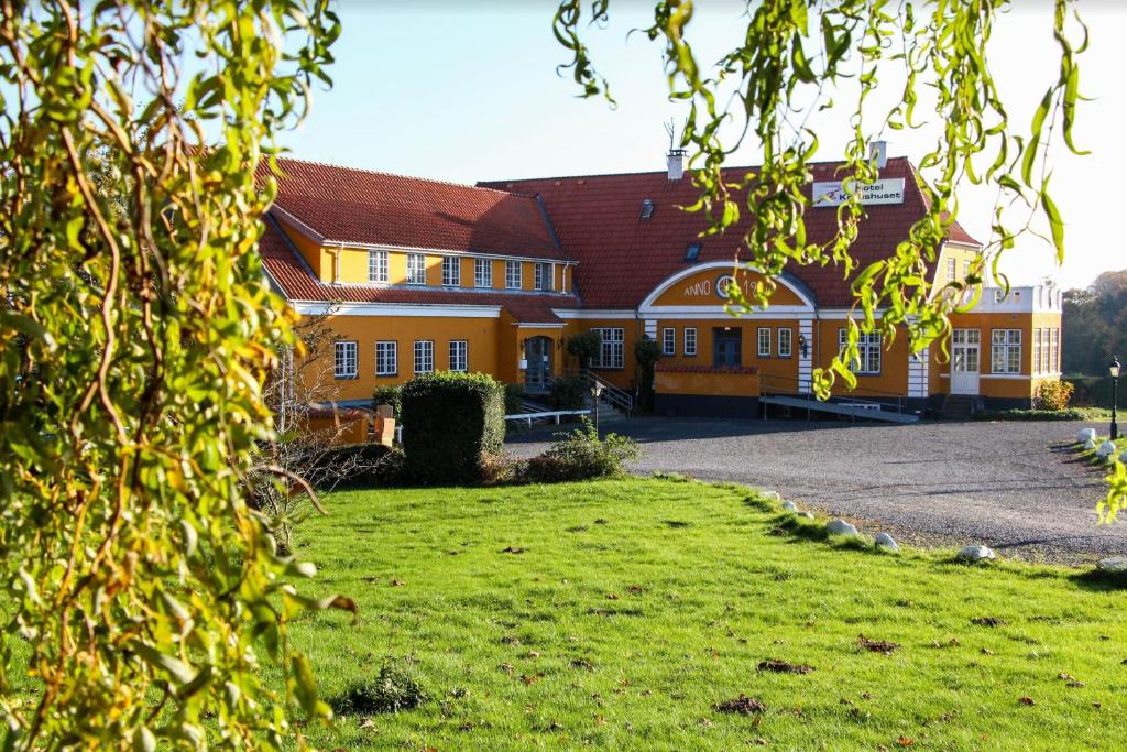 un gran edificio naranja con un campo de césped delante de él en Krebshuset / Kelz0rdk, en Sorø