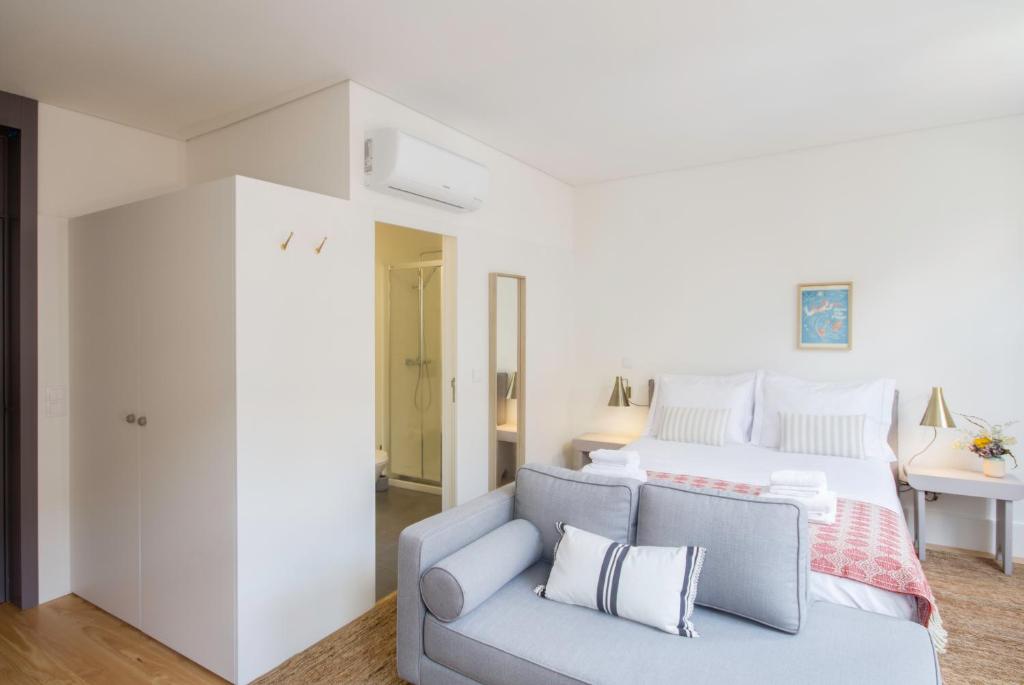 - une chambre blanche avec un lit et un canapé dans l'établissement Oporto Sweet Home III, à Porto