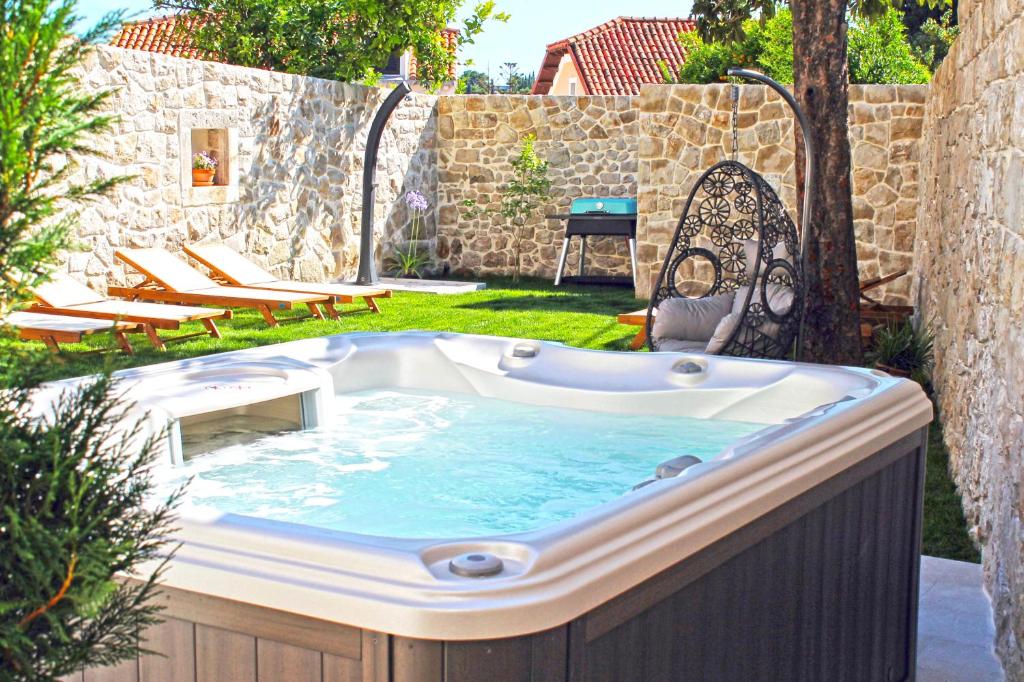 a jacuzzi tub in a yard with chairs at Villa Princess Captislava in Cavtat