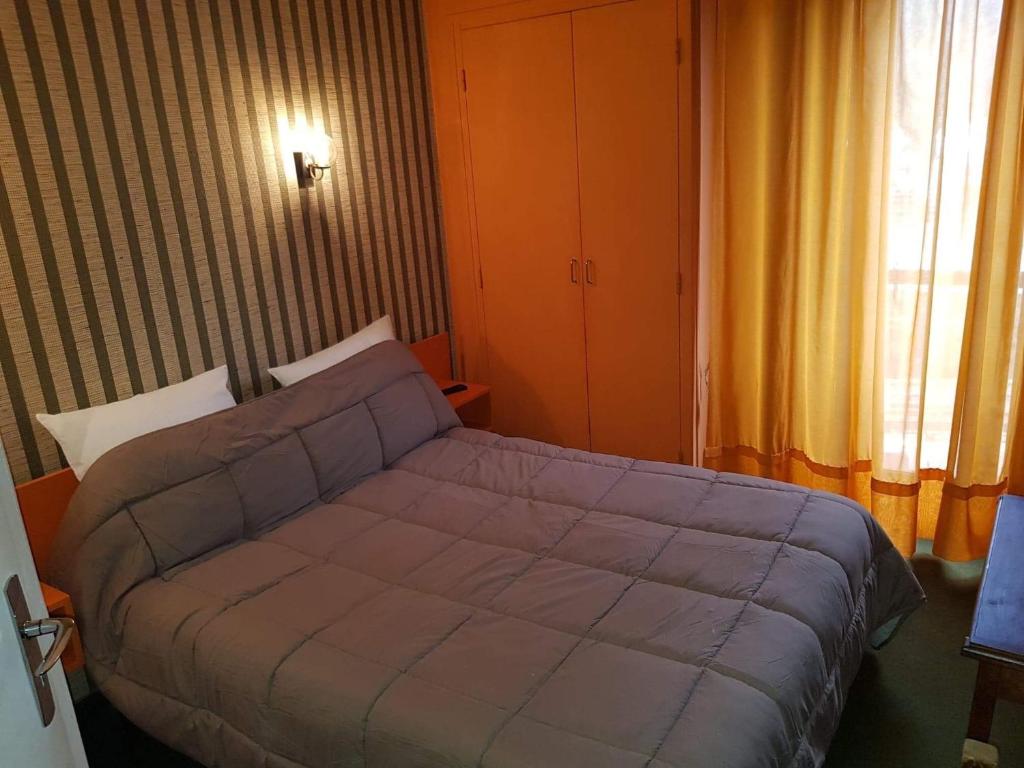 una camera da letto con un letto e una finestra di Hotel Restaurant L'AGAPANTHE a Pont-de-Salars