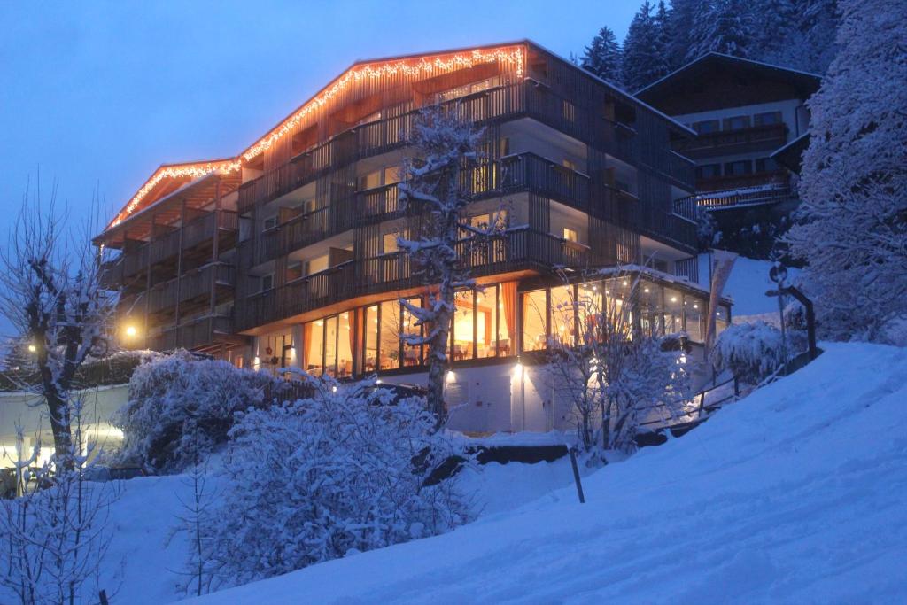 un gran edificio en la nieve por la noche en Mounthotel Niggl en Nova Levante