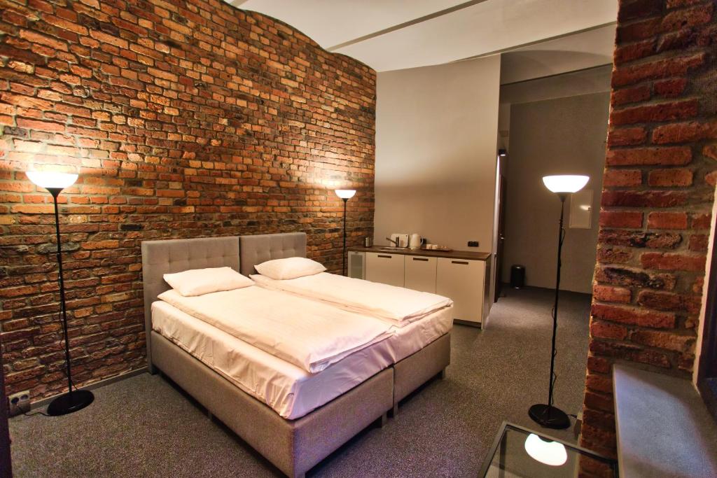ein Schlafzimmer mit einem Bett und einer Ziegelwand in der Unterkunft Stawowa 13 in Kattowitz