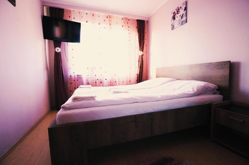 Un dormitorio con una cama grande con ventana. en HMM Apartament, en Sibiu