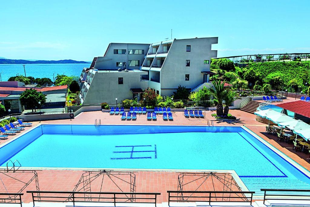 a large swimming pool in front of a building at Xenios Theoxenia Hotel in Ouranoupoli