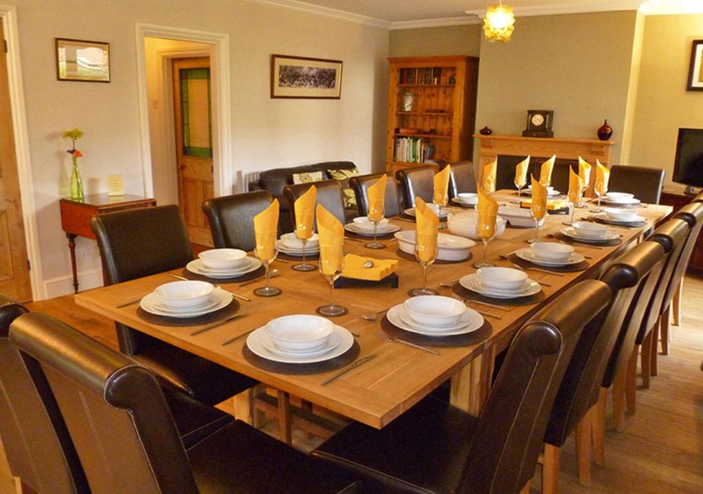 a large wooden dining room table with chairs and a large wooden table at The Dairy House in Gosport