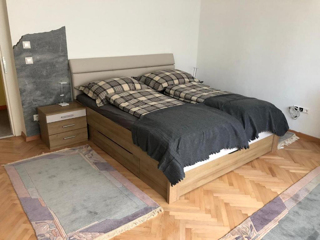 1 dormitorio con cama con marco de madera y mesa en Apartment Galapagos, en Klagenfurt
