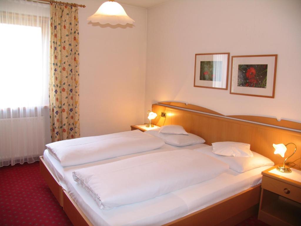 A bed or beds in a room at Hotel Reichegger