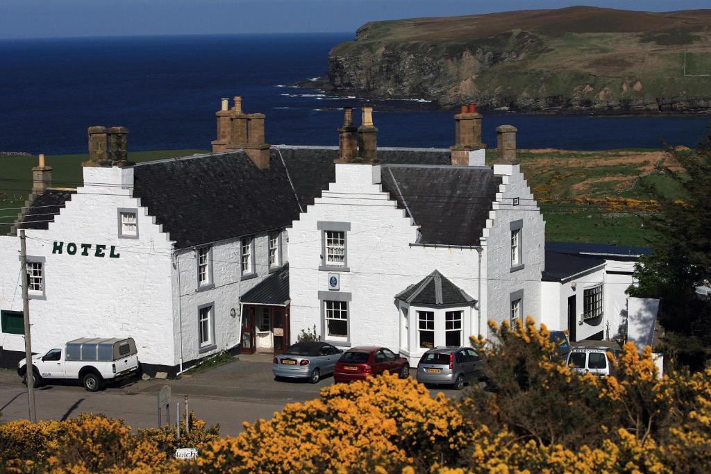 a hotel with cars parked in front of it at Melvich Hotel in Portskerra