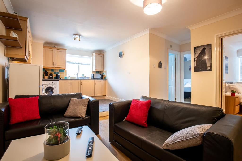 a living room with two leather couches and a table at Spacious 2BR Flat in Stansted in Stansted Mountfitchet