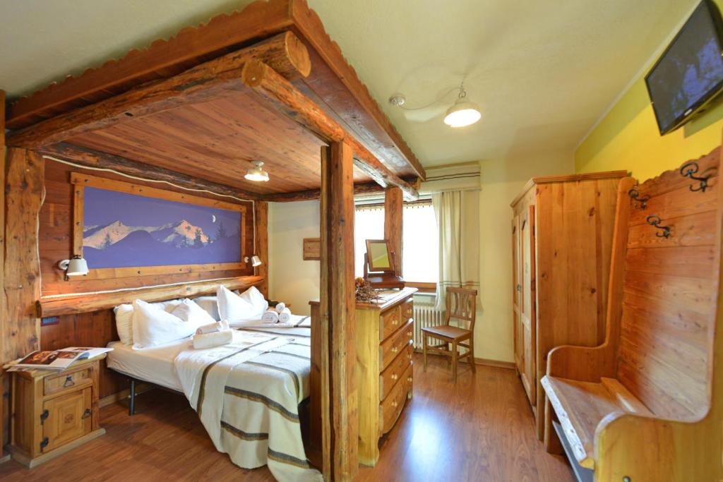 een slaapkamer met een groot bed in een kamer bij Affittacamere De Charme Jour Et Nuit in Torgnon
