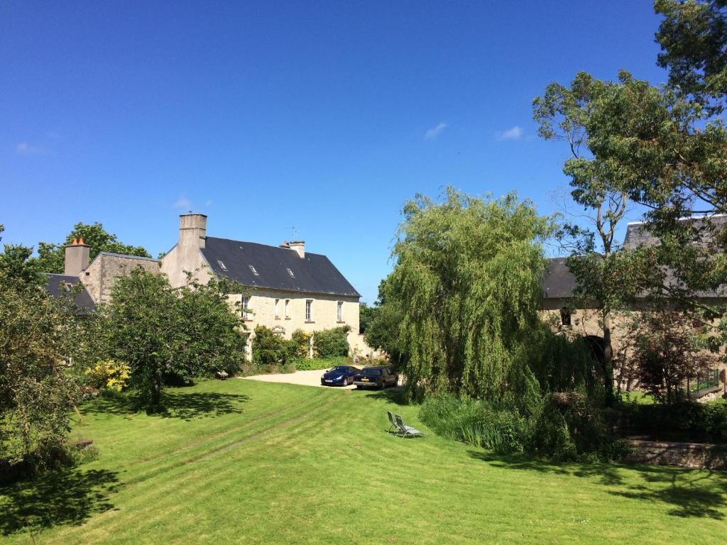 an old house with a green lawn in front of it at Le Manoir des Doyens Loft - Sleeps 8 - D-Day Museum on-site - Ten Minute Walk to Commonwealth Cemetery! in Bayeux