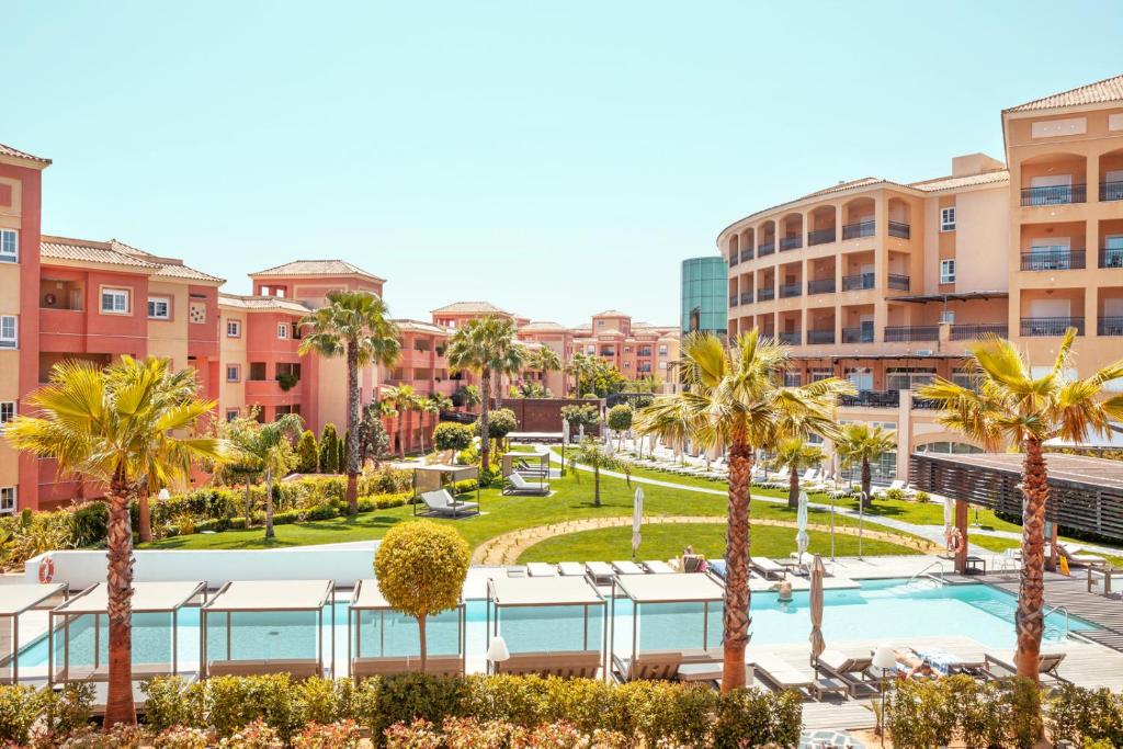 a view of a resort with palm trees and a pool at Ama Islantilla Resort in Islantilla