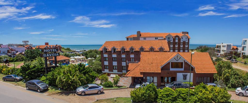 a building with a red roof and cars parked in a parking lot at Hotel Savoia Ostende in Ostende