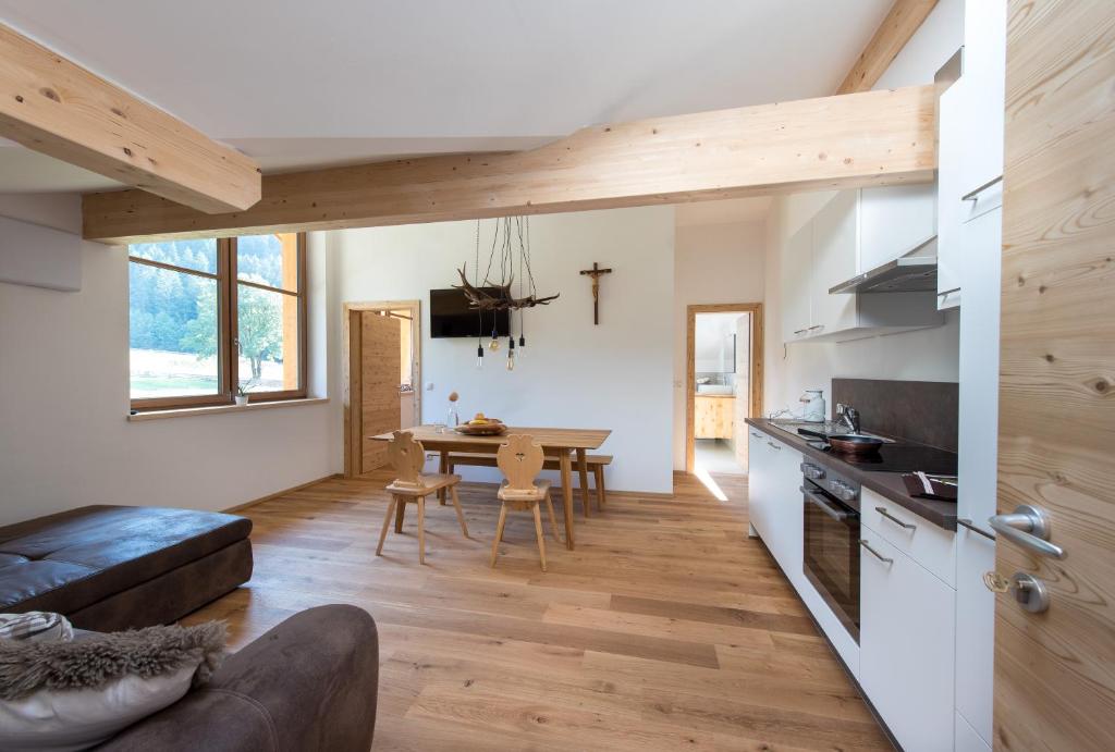 a kitchen and living room with a table and a couch at Seebacher Apartments in Sarntal