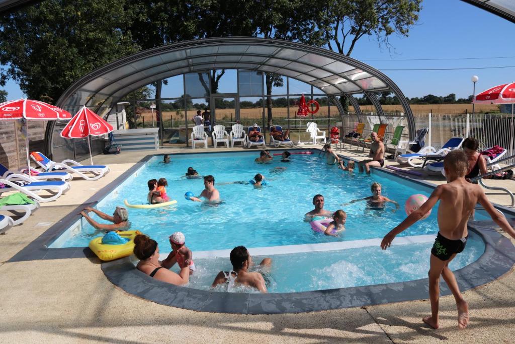 un groupe de personnes dans une piscine dans l'établissement Camping le Clos de Balleroy, à Balleroy