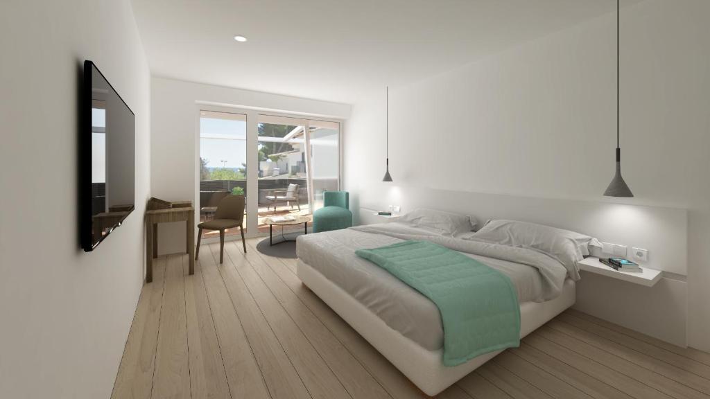 a white bedroom with a large bed and a table at Hotel hcp in Calella de Palafrugell