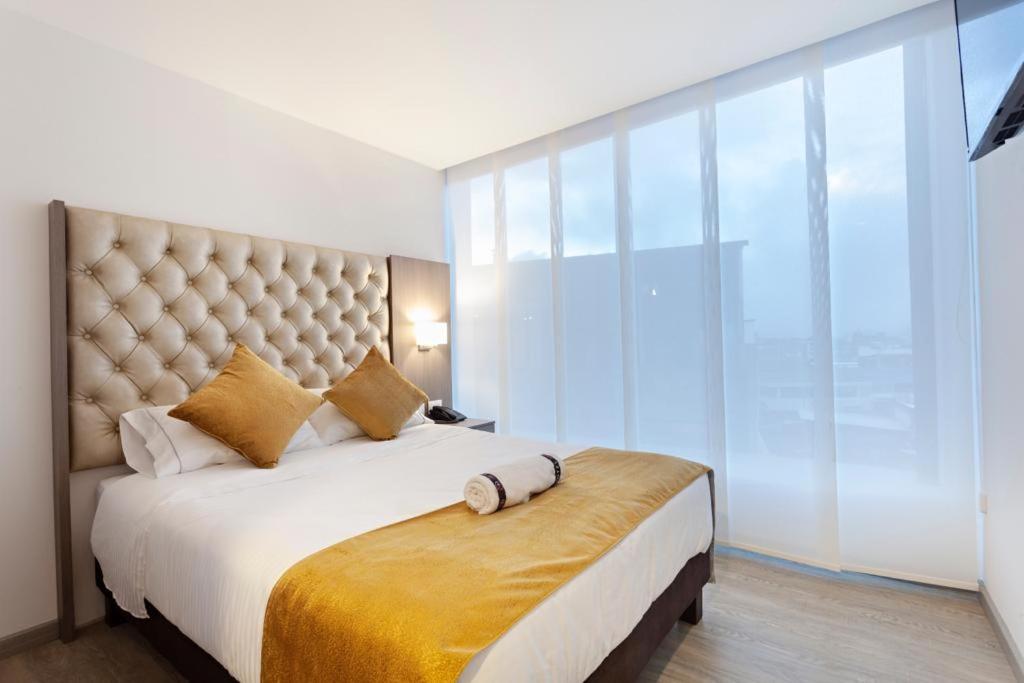 1 dormitorio con 1 cama grande y ventana grande en Hotel Max en Pasto
