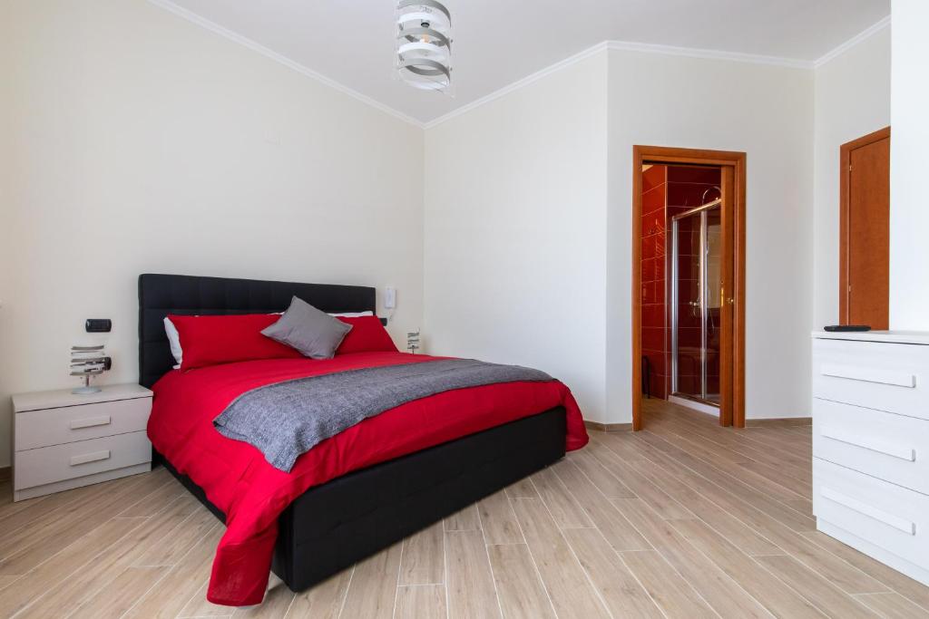 ein Schlafzimmer mit einem Bett mit einer roten Decke in der Unterkunft Napoli d'Amare B&B in Neapel