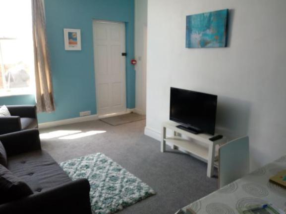 a living room with a couch and a flat screen tv at Belle Vue Bridlington in Bridlington