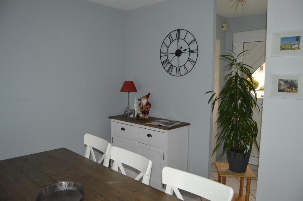 uma sala de jantar com uma mesa e um relógio na parede em Au Pays de la Potasse em Ungersheim