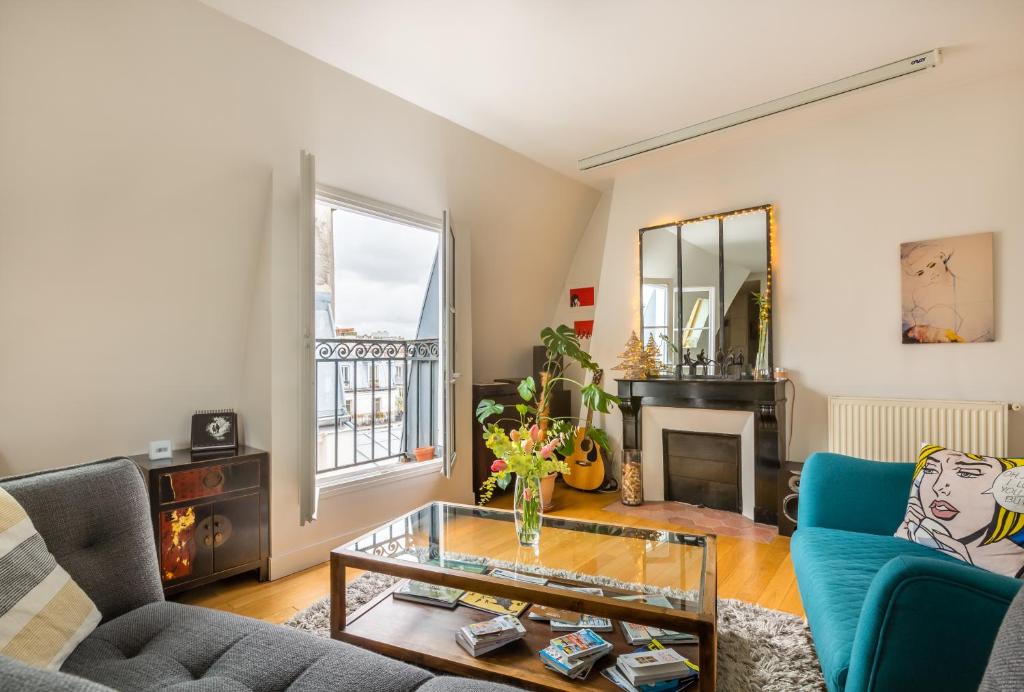 ein Wohnzimmer mit einem Sofa und einem Tisch in der Unterkunft Veeve - Rooftop Views By the Canal Saint-Martin in Paris