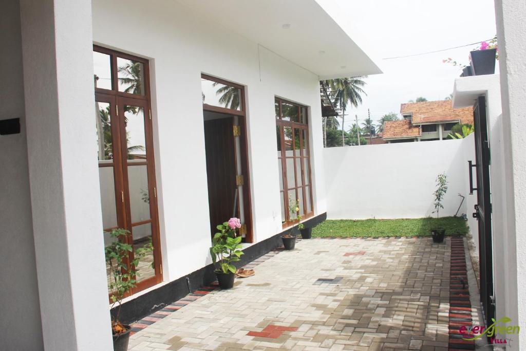 Casa blanca con ventanas y pasarela en Ever Green Villa, en Negombo