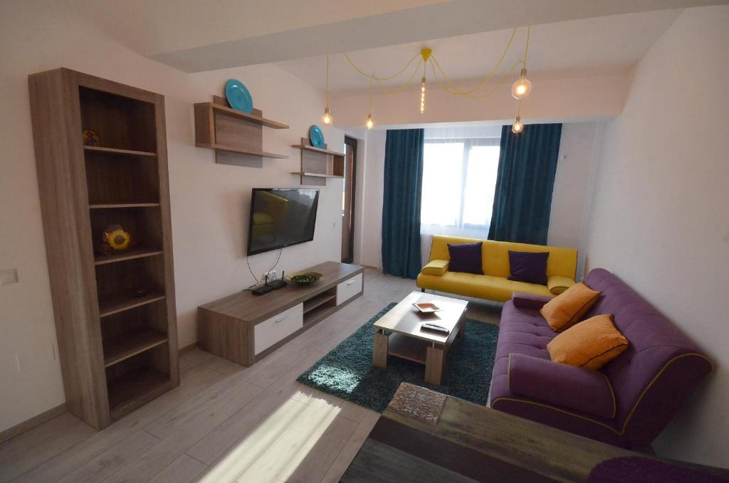 un salon avec un canapé violet et une télévision dans l'établissement Rya Home 1, à Bucarest