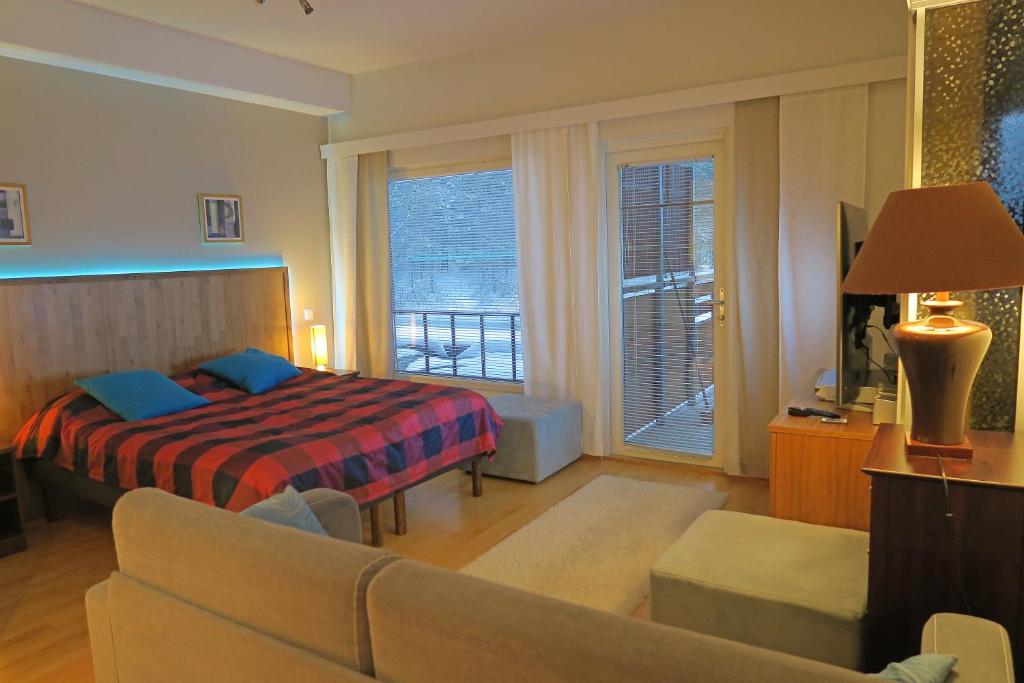 ein Schlafzimmer mit einem Bett und einem Sofa in einem Zimmer in der Unterkunft Apartments Tähtitahko in Tahkovuori