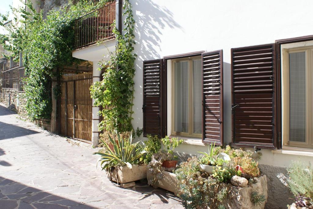 a house with wooden shutters on the side of it at Apricot House in Roccascalegna