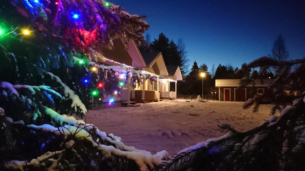 a christmas tree with christmas lights on it at Taljatie Apartments in Rovaniemi