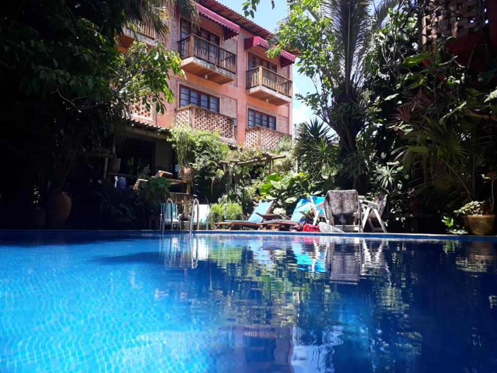 a swimming pool in front of a hotel at Pousada Pilar in Arraial do Cabo