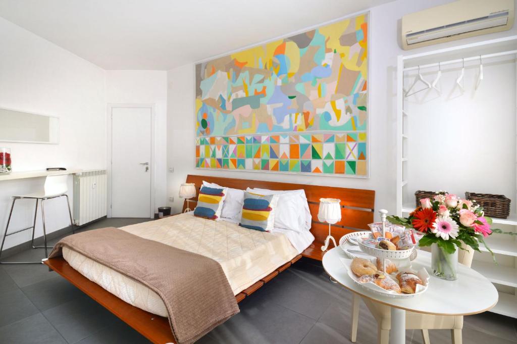 sypialnia z łóżkiem, stołem i obrazem w obiekcie LA LOCANDA DELL'ARTE-DE GASPERI w mieście Napoli