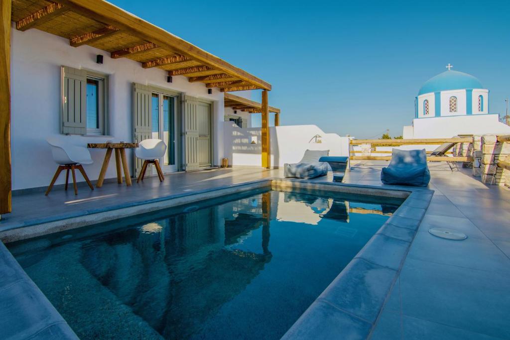 a swimming pool in front of a house at Aeris suites in Koufonisia