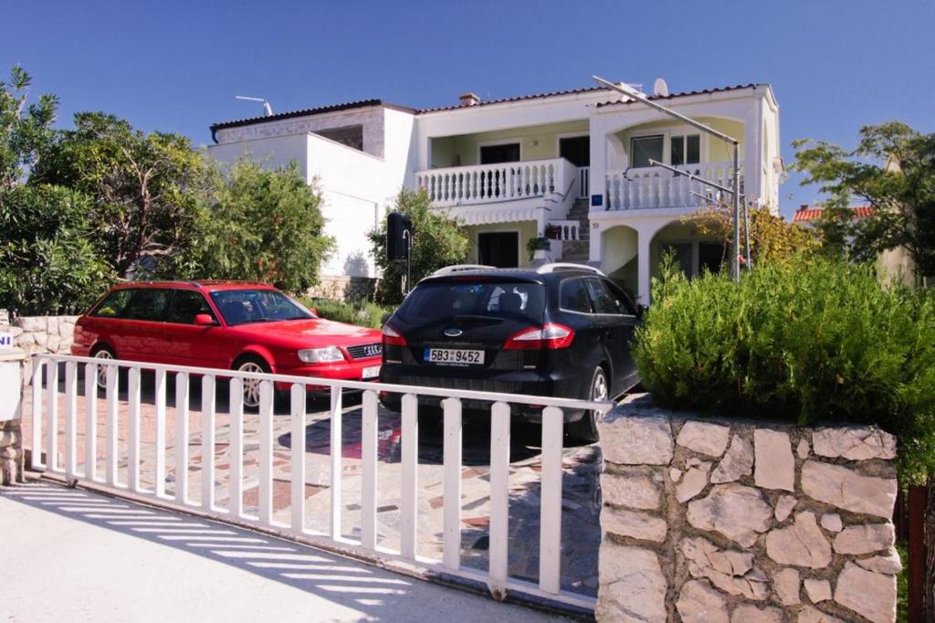 波弗加納的住宿－Apartments Bresina，两辆汽车停在房子前面