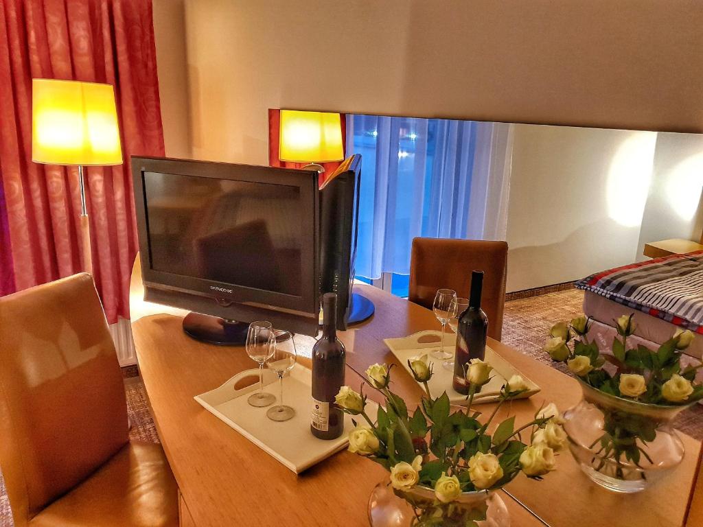 ein Zimmer mit einem Tisch mit einem TV und Blumen darauf in der Unterkunft Noclegi Portowa in Oppeln