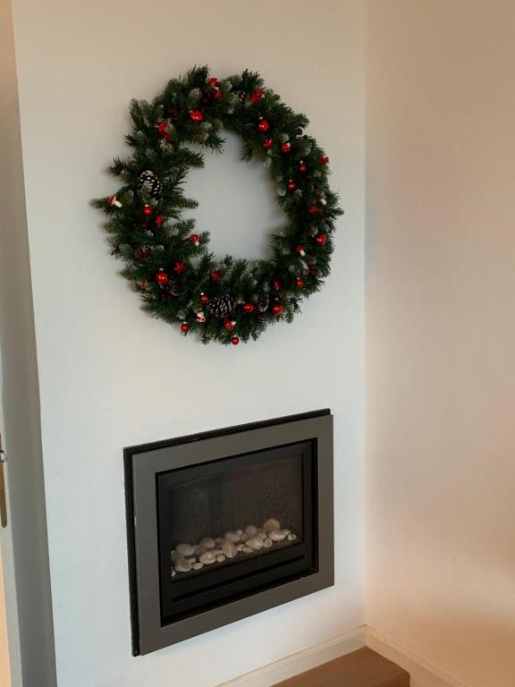 a wreath over a fireplace with a christmas wreath at Apartment Thalassa in Blankenberge