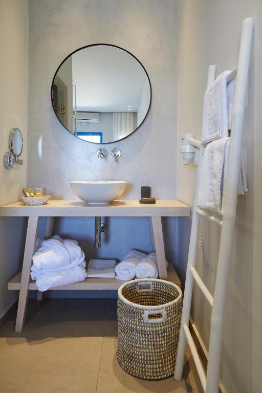 a bathroom with a sink and a mirror and towels at Vigla Hotel in Aegiali