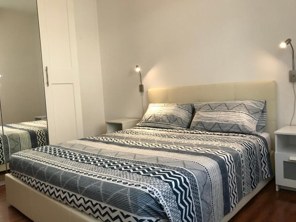 1 dormitorio con 1 cama grande con sábanas azules y blancas en Appartamento Giuliana Cervia en Cervia